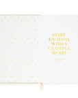 Notebook with gold polka dots and text on a white background