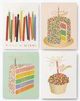 A set of four birthday cards with colorful candle designs, placed outside a paper-wrapped box with gold foil accents.