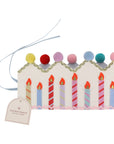 Decorative birthday cake crown with candles and pom-pom crown on a white background