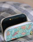 Opened view of the zipper wallet with a striped fabric in the background