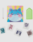 Inside contents of the Cutesy Cat theme DIY Mini Gem Art Kit, showing the completed gem art and including a gem tray, wax pencil, and five gem packs.