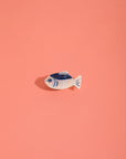 Small fish-shaped object on a pink background