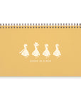yellow notebook with 4 ducks illustration and "ducks in a row" text on white background
