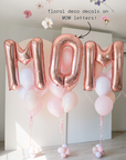 Rose gold letter balloons reading "MOM" with floral decals
