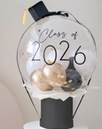 Decorative item with 'Class of 2026' text inside a transparent sphere on a white pedestal.