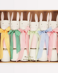 A set of six Easter-themed bunny crackers in a box, featuring gingham ribbons and tissue paper hats in various colors.