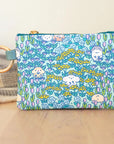 A multicolored coin purse with a brass zipper and a metal key ring, featuring a pattern of hamsters, flowers, and leaves on a blue background.