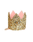 A mini gold glitter crown hair clip with a pink felt lining.