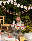 Outdoor setting with a small table, chair, and decorative banners in garden