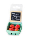 Packaged strawberry magnets with a small basket on a white background