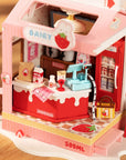 A close up picture of a pink and red miniature toy milk carton shop set with detailed interior shelves, a counter, and small accessories