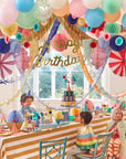 Children at a birthday party with colorful decorations and balloons.