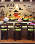 Model sushi restaurant with sushi display and chairs against a sushi-themed wall.