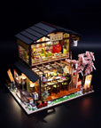 Detailed model of a Japanese restaurant with cherry blossom tree on a dark background