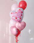 Red and pink small balloon bouquet featuring a vintage heart shaped cake