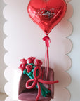 5 twisted balloon roses on a pink chair with a red happy valentine's day balloon heart