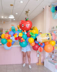 a 7ft balloon garland with in colorful shades with back to school shapes and honeycomb add-ins