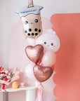 A balloon bouquet featuring a boba bubble tea character balloon, a dumpling with a heart face balloon, and a variety of other balloons in pink, red, and white colors with 'love you' and 'xoxo' decals.