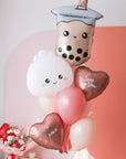 A balloon bouquet featuring a boba bubble tea character balloon, a dumpling with a heart face balloon, and a variety of other balloons in pink, red, and white colors with 'love you' and 'xoxo' decals.
