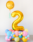A balloon cloud with a large gold number 2 in the center, surrounded by multicolored balls in shades of pink, yellow, and blue.