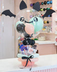 Halloween-themed bubble balloon with candy inside on a table.