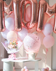 MOM rose gold balloons with a flower balloon bouquet and a round pink "Happy Mother's Day " balloon on a table