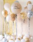Cream round balloon with black bow and silver metallic tinsel. Text reads "3..2..1.. Happy new Year!" with gold tinsel and cream backdrop. Floating balloon with black ribbon bows in various sizes surrounding. Balloons tossed on the floor.