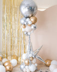 nye 2025 balloon tower with a giant round silver balloon and clusters of gold, silver and cream balloons underneath on a stand