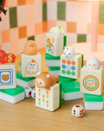 6 mahjong themed vinyl toys with a cute cartoon character on top, on tabletop with colorful wallpaper