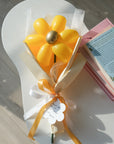 goldenrod balloon daisy on a coffee table with books
