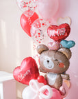 A Valentine's Day balloon present featuring a heart-shaped balloon with the name 'Olivia', a teddy bear holding balloons