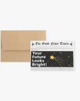 A greeting card with a 'Future Looks Bright' message, displayed in front of a newsprint background, indicating a humorous or celebratory tone. An envelope is also shown to the left of the card.