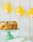 felt chick banner hung over a cake on a stand