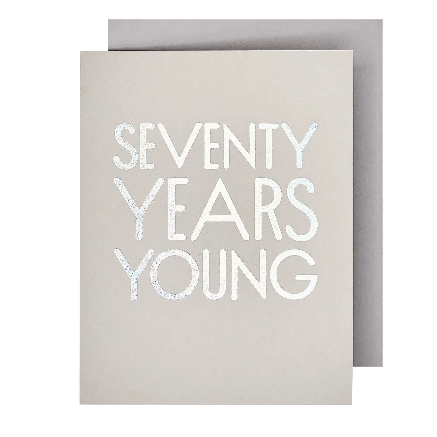 A gray birthday card with 'SEVENTY YEARS YOUNG' embossed in white text on the front, accompanied by a gray envelope.