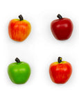 Four small apple-shaped items including two red apples and two green/red apples, each with a dark stem.