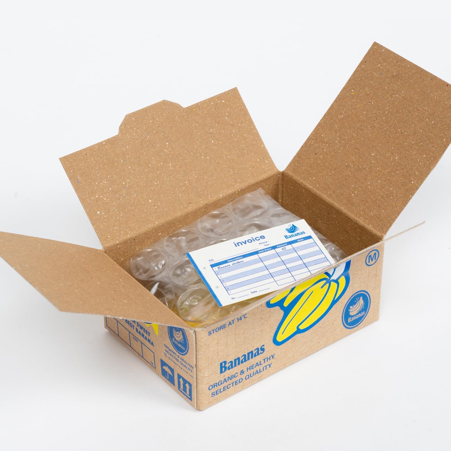 Open cardboard box with plastic bags and an invoice on a white background