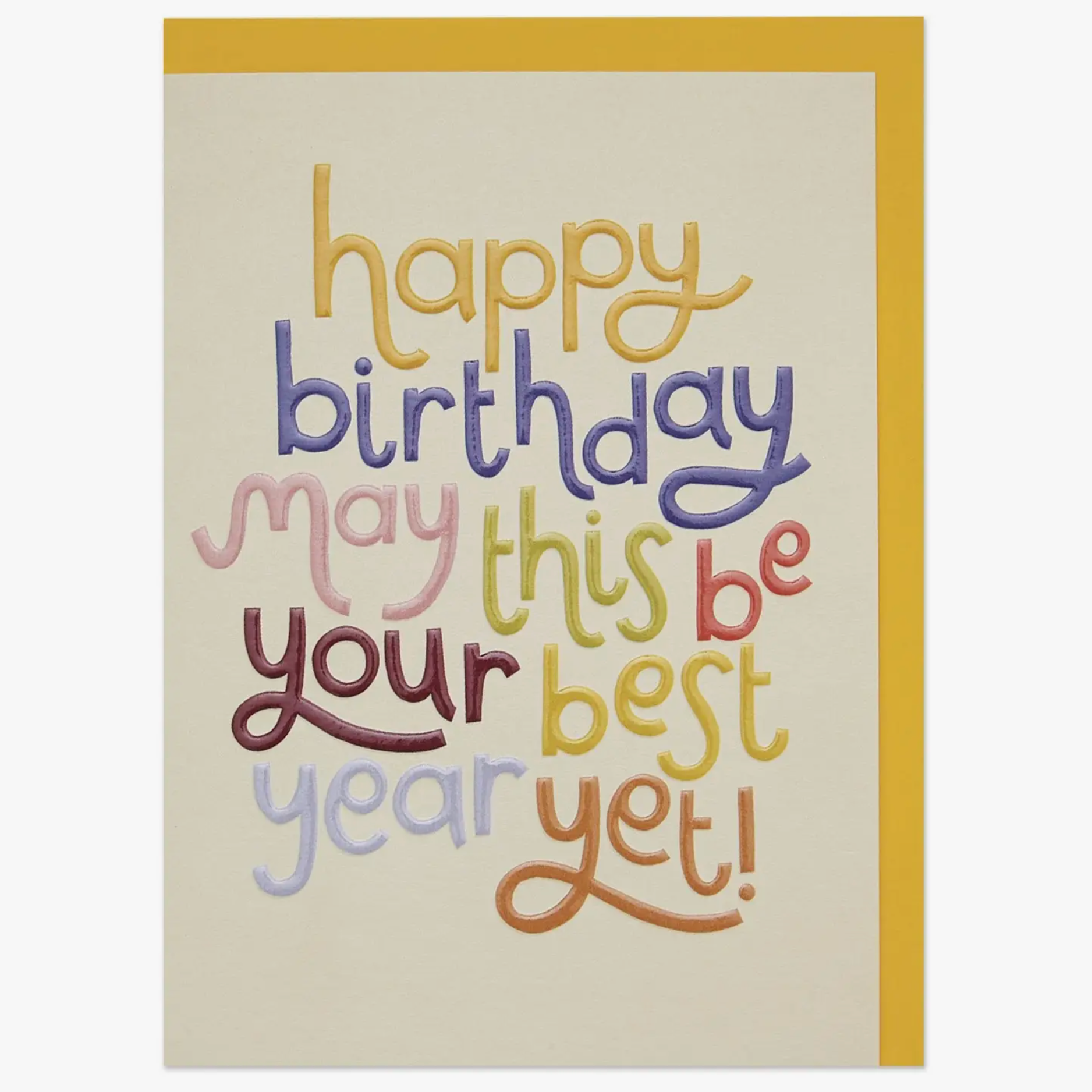 A colorful birthday card with the text 'HAPPY BIRTHDAY' and 'MAY THIS BE YOUR BEST YEAR YET!' in various colors on a beige background, accompanied by a harvest yellow envelope.