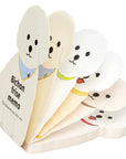 Dog-shaped memo pads with cartoon faces on a white background
