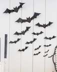 A wall decorated with black glittery bats