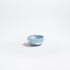 Small blue ceramic bowl with white cloud patterns on a light gray background