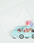 pop up 3d card featuring blue car with dogs inside, "happy birthday" text on the side, with white envelope