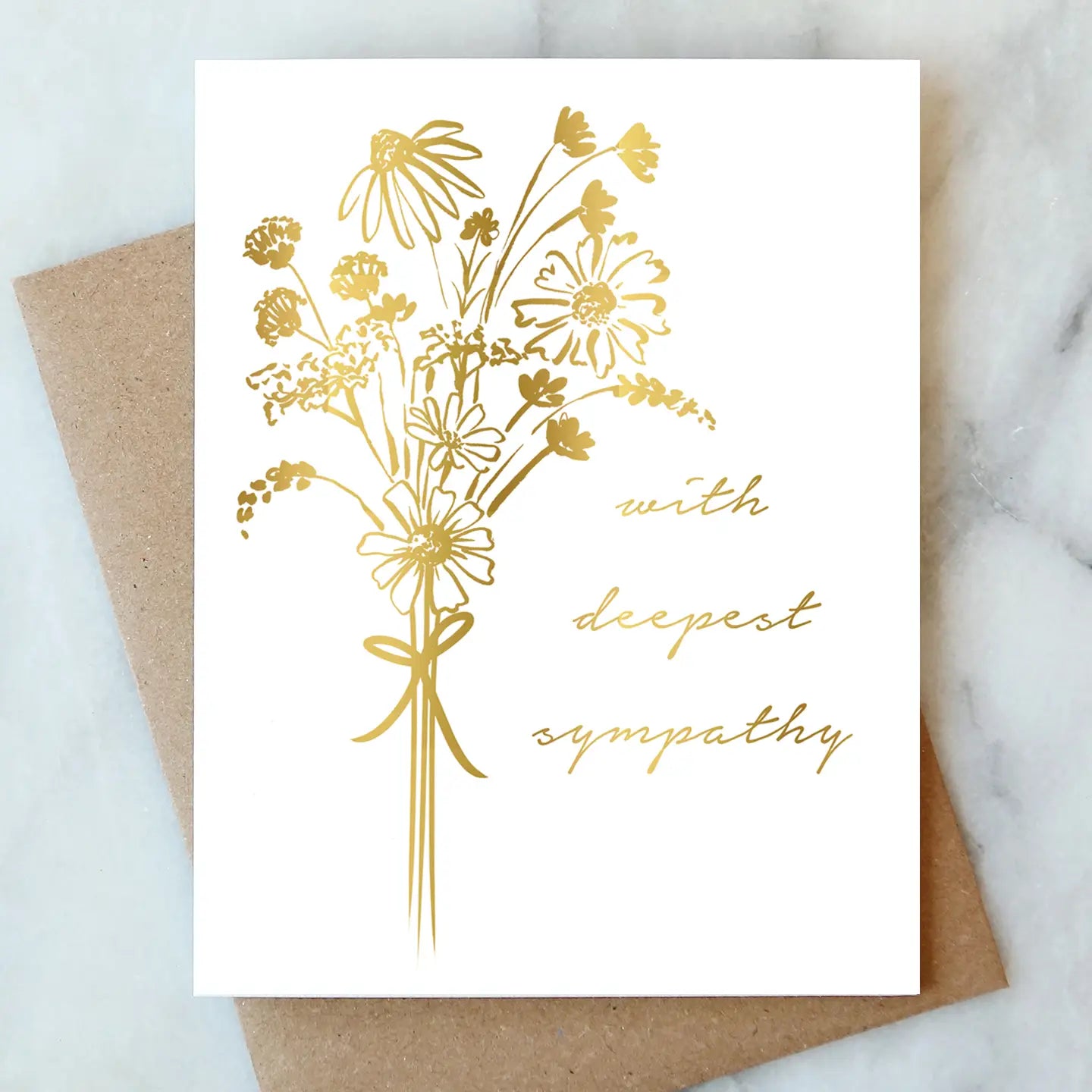 Greeting card with gold floral design and 'with deepest sympathy' text on a marble surface.