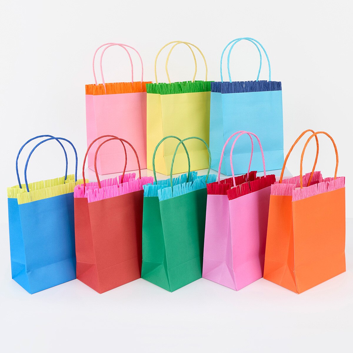 Colorful paper gift bags with handles on a white background