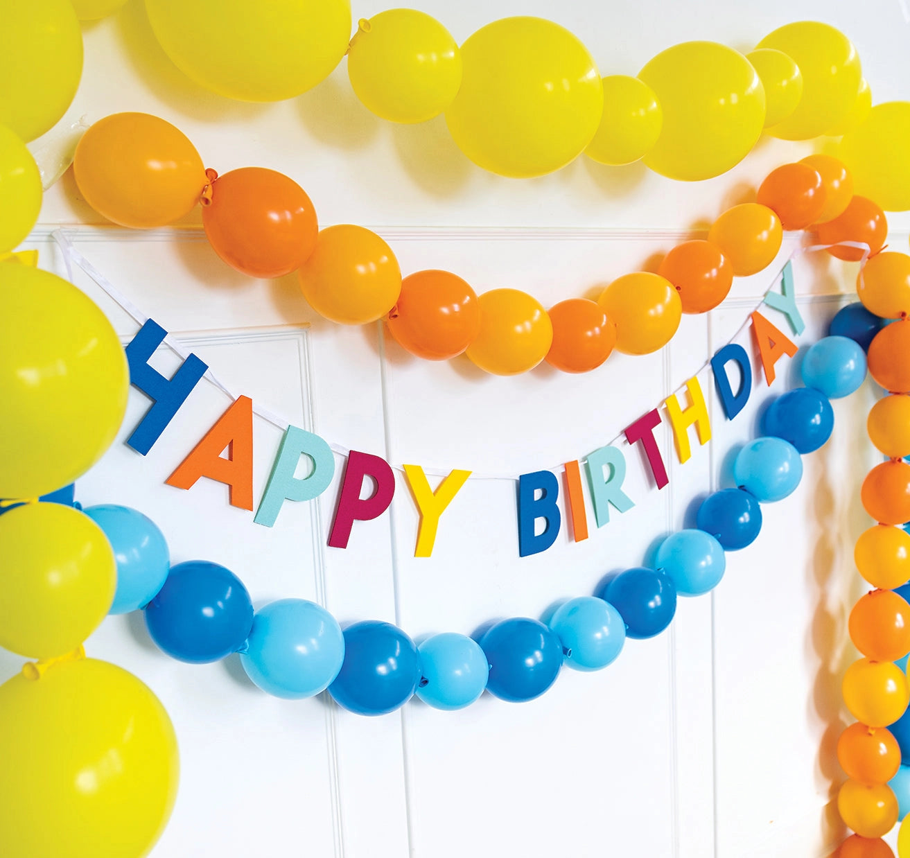 Colorful banner with 'Happy Birthday' text and balloons on a white background