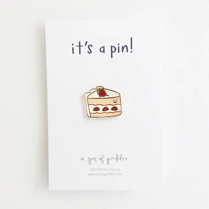 pin featuring a smiley slice of strawberry cake on white background
