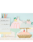 A folded view of the greeting card designed to look like a variety of cakes with decorations and a text that reads 'HAVE YOUR CAKE AND EAT IT TOO'. The card is folded and displayed with a mint envelope.