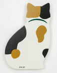 Cat-shaped object with black, brown, and white colors on a light gray background
