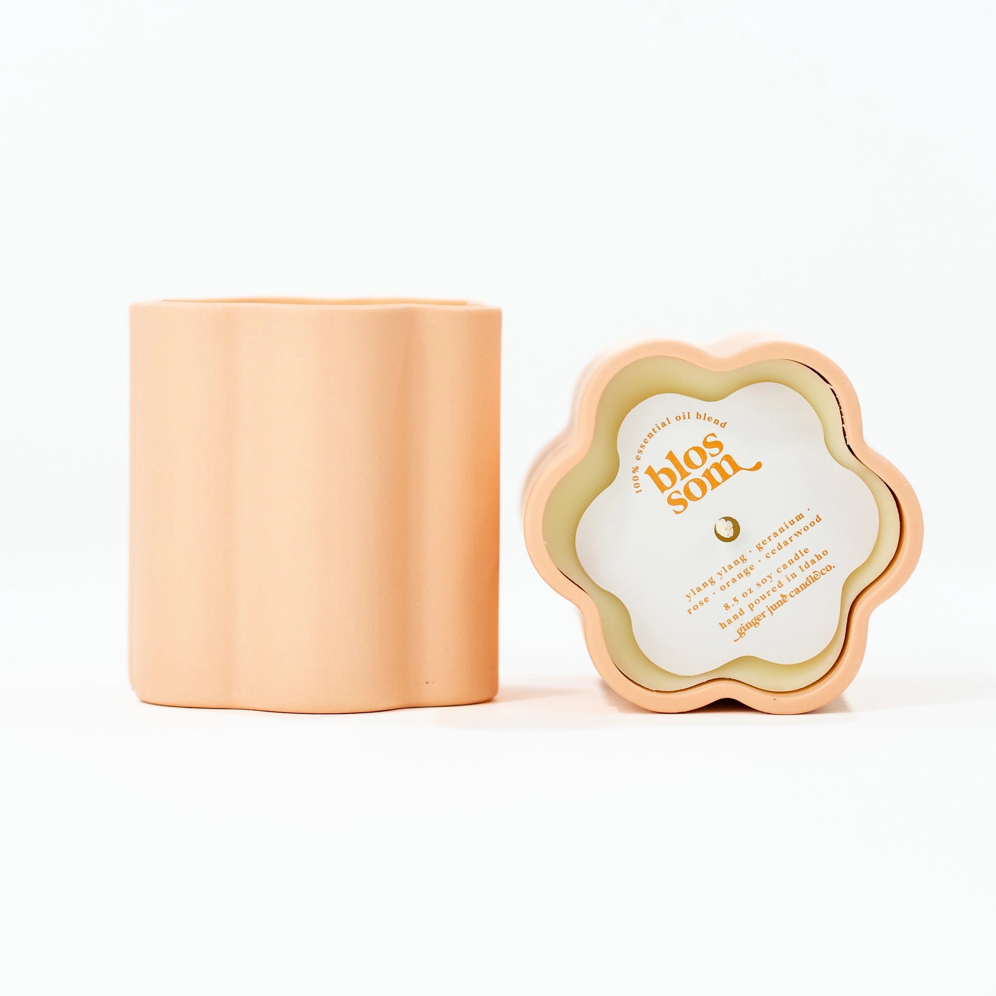 peach container of a candle's side view and top view. Top view has paper cover of scent and text
