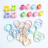 A collection of colorful hair claws and ties designed to look like cherries and strawberries, laid out on a white surface.