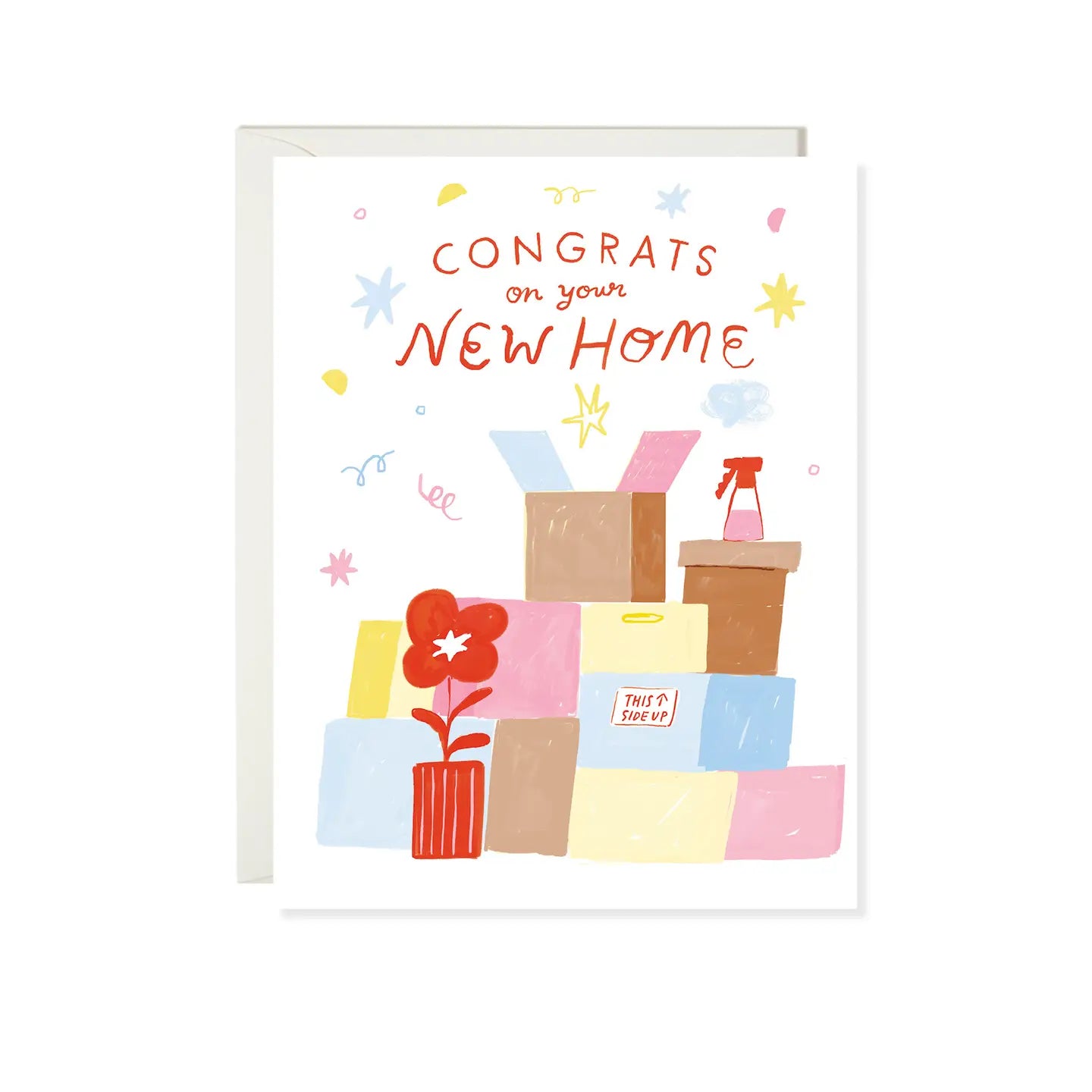 A folded greeting card with a colorful design featuring text 'CONGRATS ON YOUR NEW HOME' along with images of moving boxes and a flower, paired with an envelope.